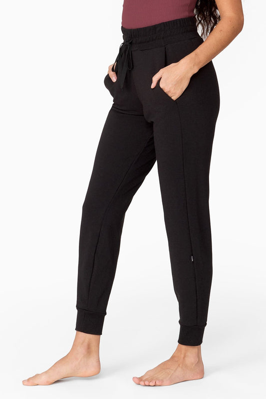 half view of a woman wearing black fleece joggers with pockets