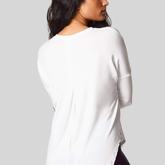 A brunette shows us the back pleat in her white 3/4 length sleeve tee-shirt.