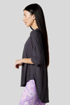 Side of a women wearing a dark grey 3/4 length sleeve shirt