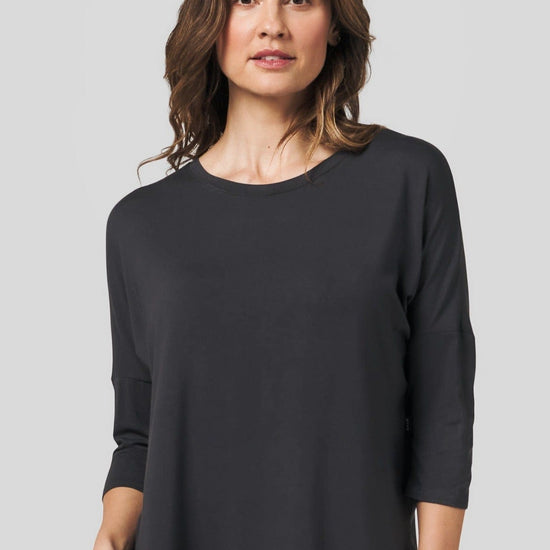 Woman wearing a dark grey 3/4 length sleeve shirt
