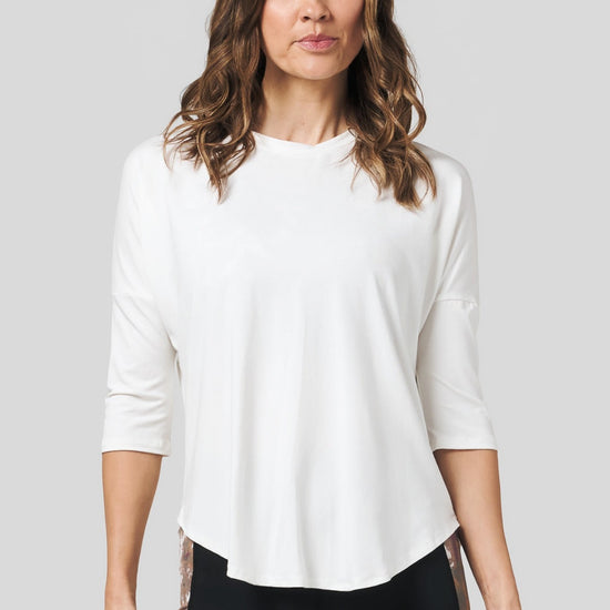 Women wearing a off white 3/4 length sleeve shirt and pocket legging.
