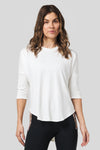 Women wearing a off white 3/4 length sleeve shirt and pocket legging.
