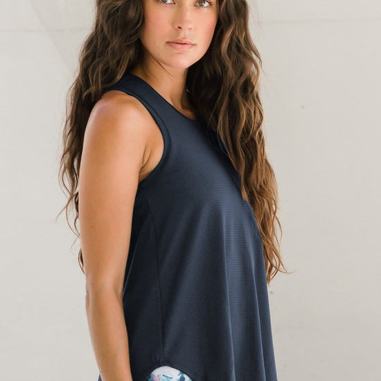 A woman wearing a dark blue gray tank top