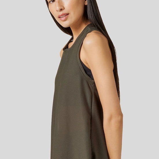 Side of a women wearing olive green tank top and green legging