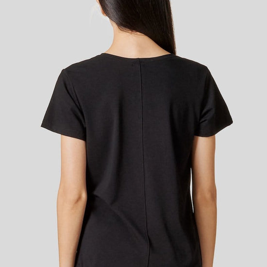 Back of a woman wearing a black short sleeve shirt