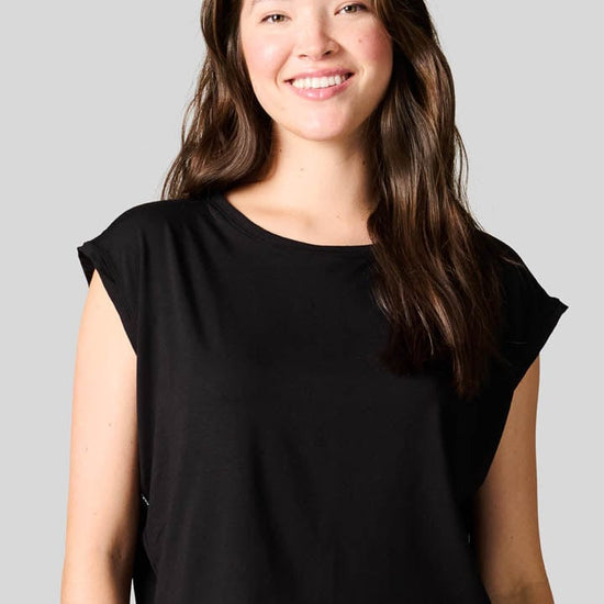 Woman smiling wearing a black box tee. 