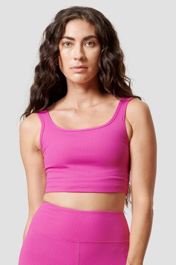 A brunette woman wears a pink reversible top.