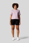 Women standing straight wearing a lavender colour tee and black shorts with Nike Air Max