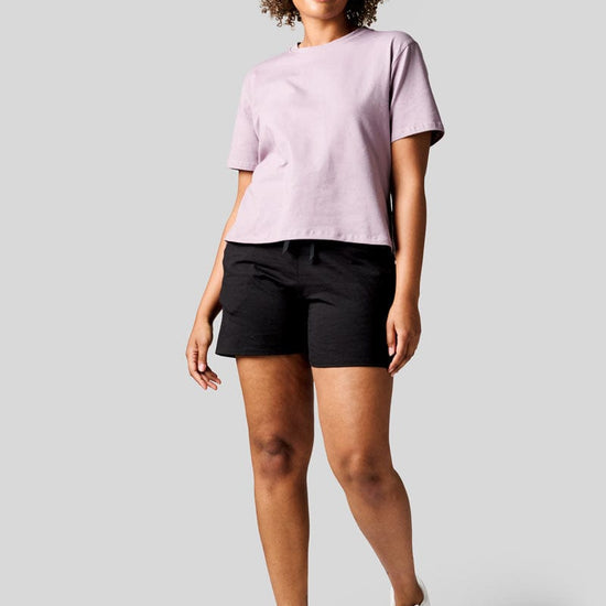 Women wearing a lavender colour tee and black shorts with Nike Air Max