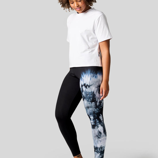 Woman wearing a white tee with one leg tie dye leggings and Nike Air Max shoes