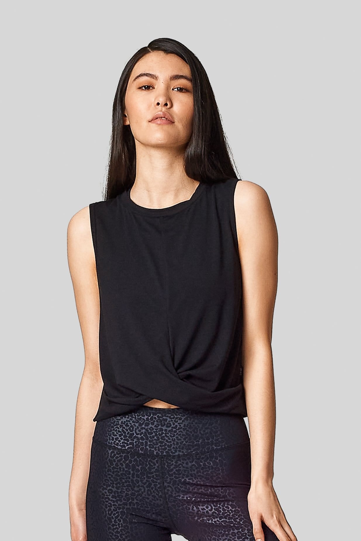 A black sleeveless tank with criss cross twisty front. Slightly cropped.