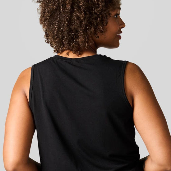 Back of a women wearing a black tank and tie dye leggings.