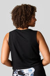 Back of a women wearing a black tank and tie dye leggings.