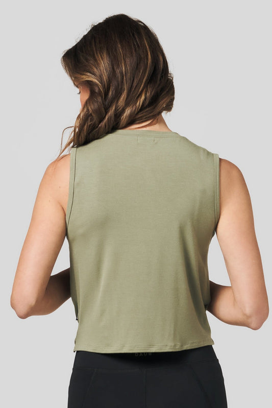 Back of a women wearing a green tank top and black legging.