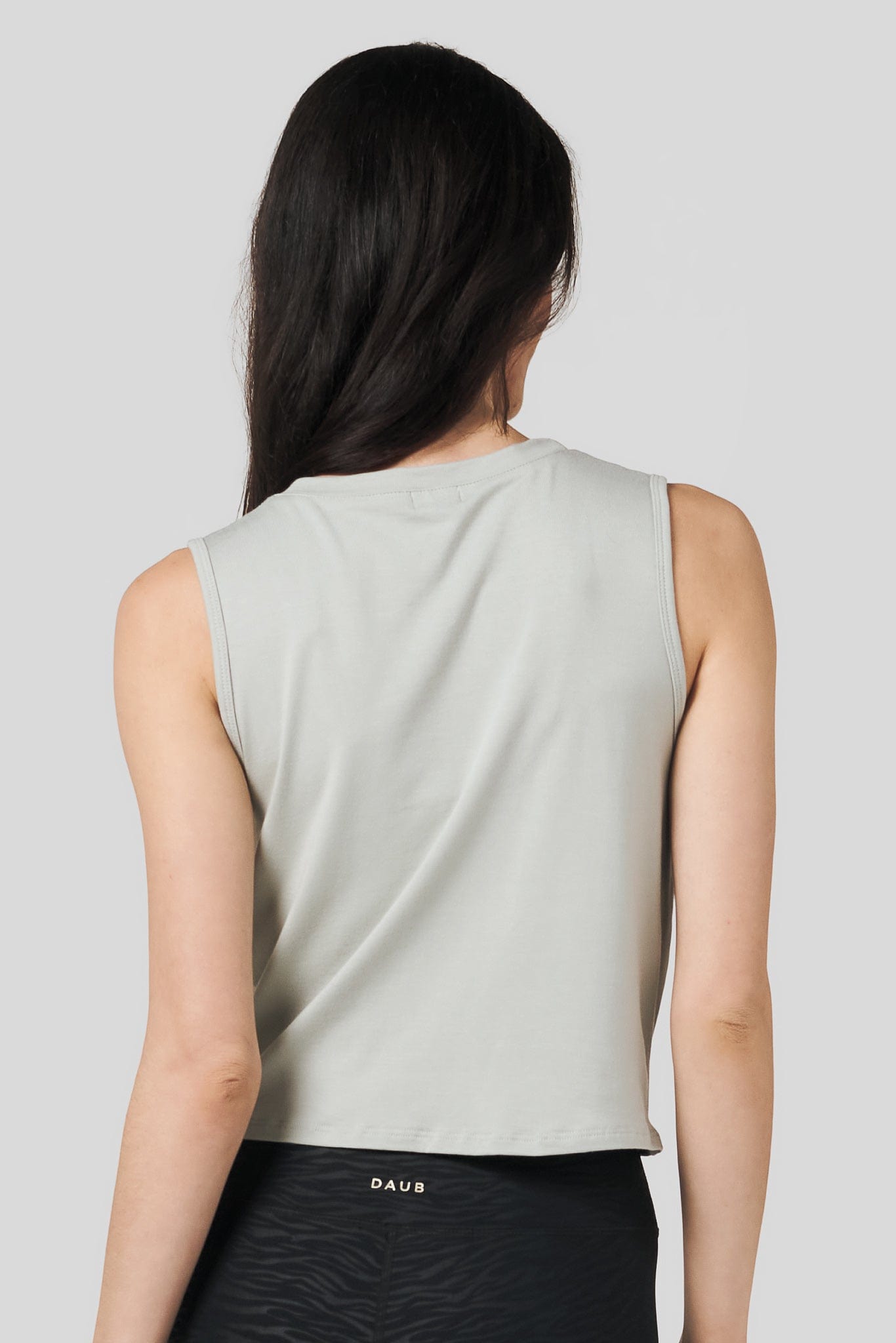 Back of a women wearing sage colour tank top and zebra print legging.
