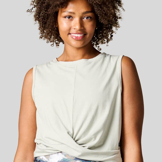 Women smiling wearing a sage tank top with a nice twisted knot.