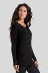 A woman wears a v-neck, long sleeve sweater made from a super soft modal fabric in black.