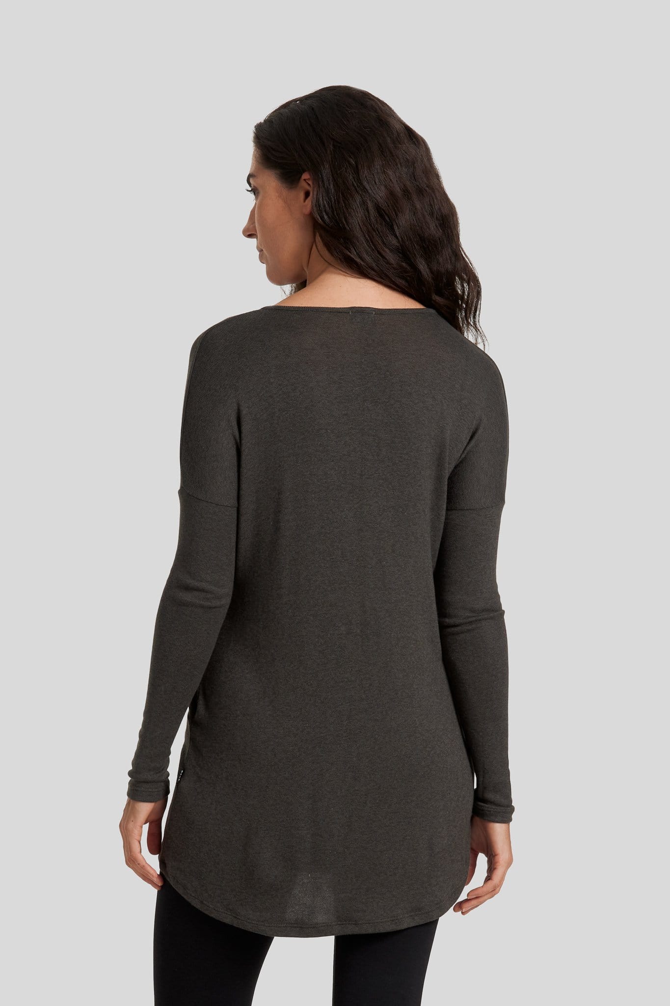 The back of a woman wearing a green sweater.