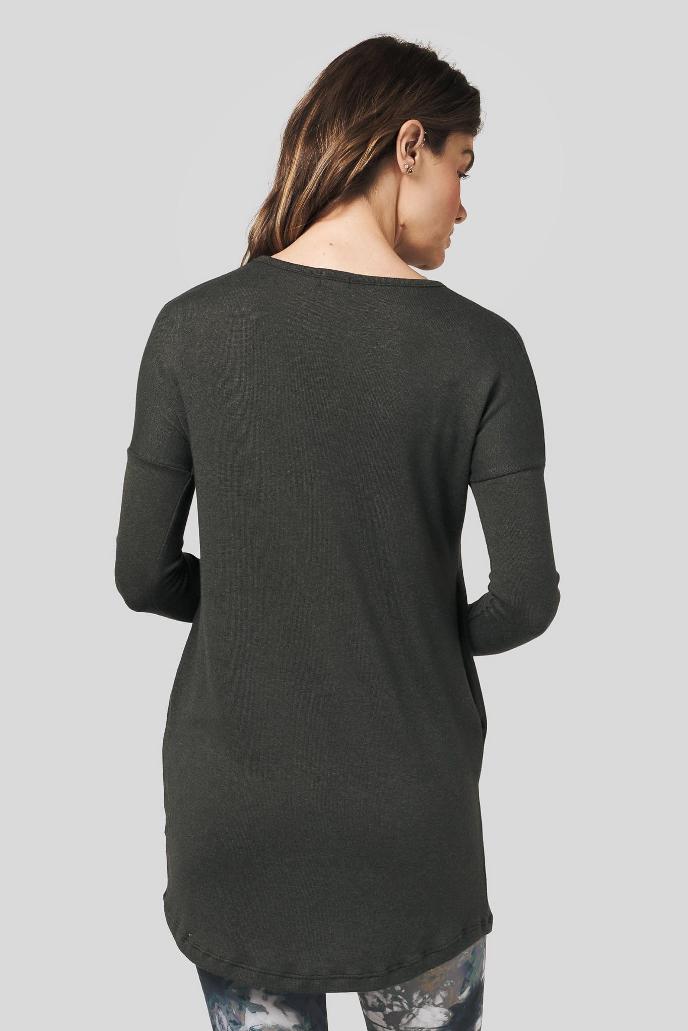 Back of a woman wearing a long sleeve sweater in green