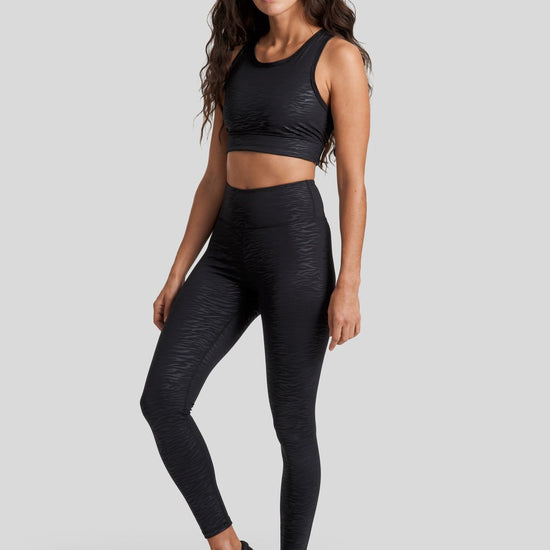 A woman wearing the Savannah Crop and Riley Leggings in Zebra with sneakers on 