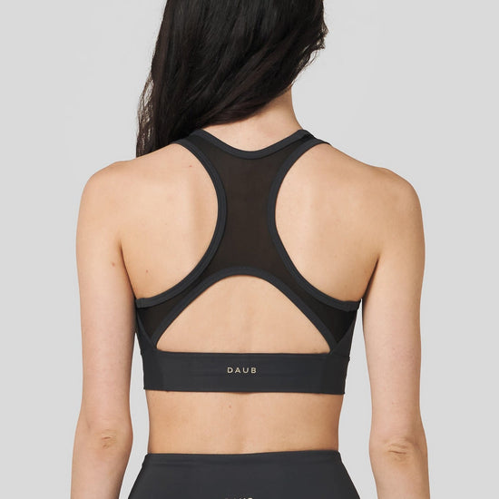 Back of a women wearing a Charcoal colour sports bra.