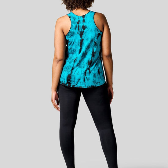 Back of a women wearing a blue tie dye tank top, black leggings and Nike Air Force shoes