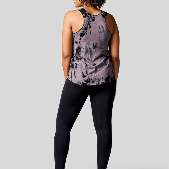 Back of a women wearing a tie dye tank top, black leggings and Nike Air Force shoes