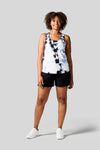 Women wears a white Tie Dye tank top, black shorts and Nike Air Max shoes.