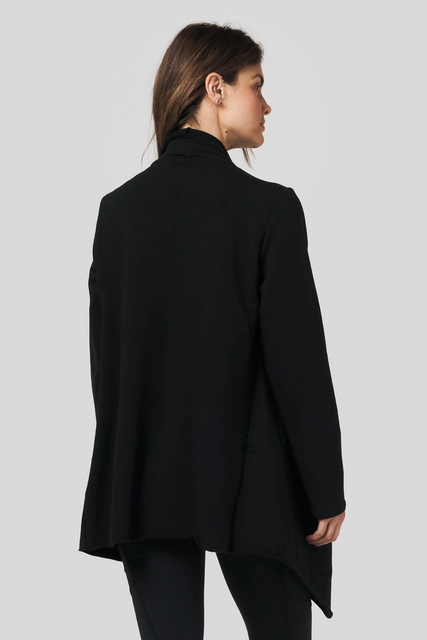 Back of a women wearing a black fleece jacket and black leggings