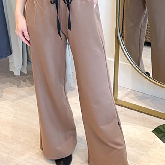 Women wearing wide leg sweatpants in brown and boots
