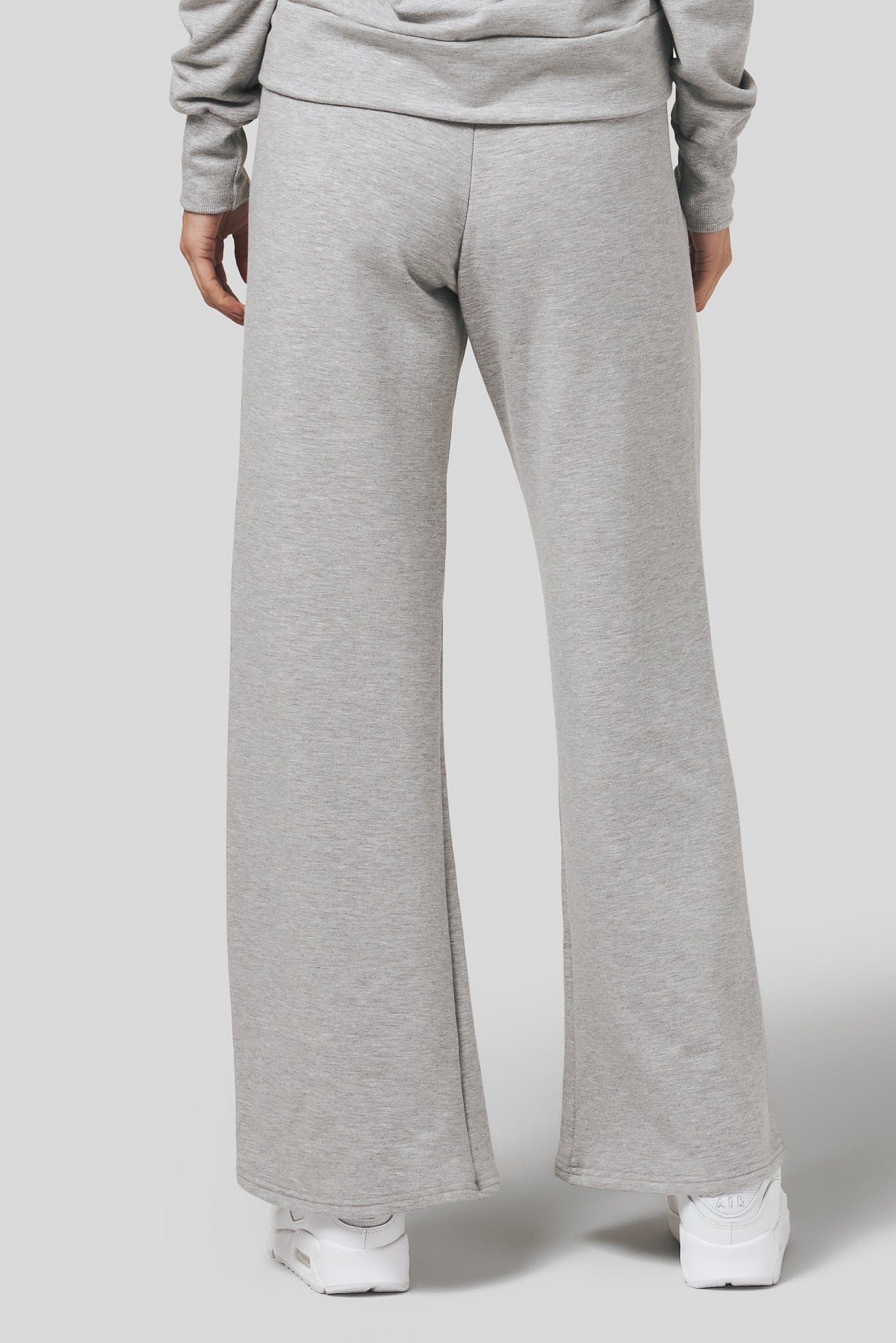 Back of a women wearing a wide leg sweatpants in light heather grey