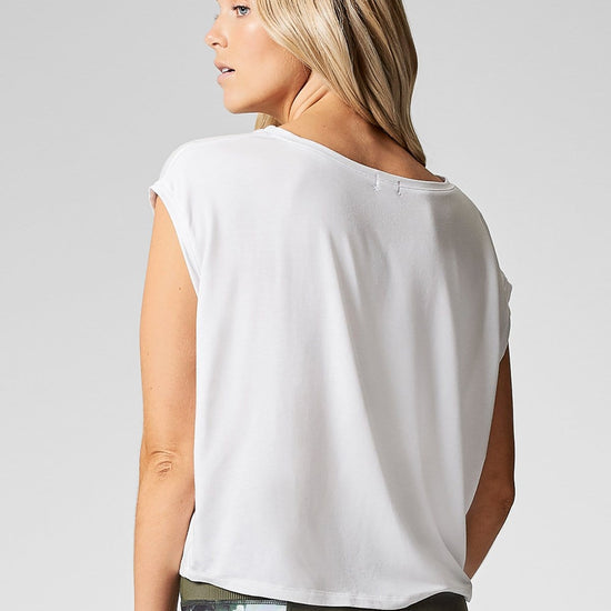 A blond woman wears a white boat neck, box tee shirt made from modal.