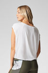 A blond woman wears a white boat neck, box tee shirt made from modal.
