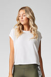 A woman with blond hair wears a white t-shirt made from modal that is cropped at the hip.
