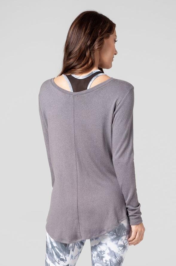 A woman is shown from the back wearing a grey long sleeved top. 
