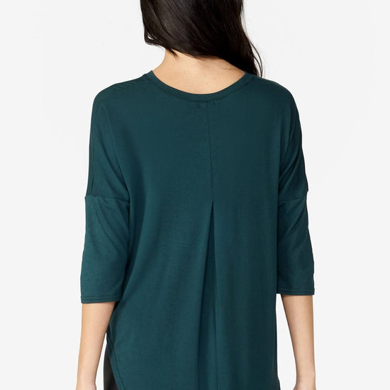 back of a Woman wearing a green 3/4 length tee.