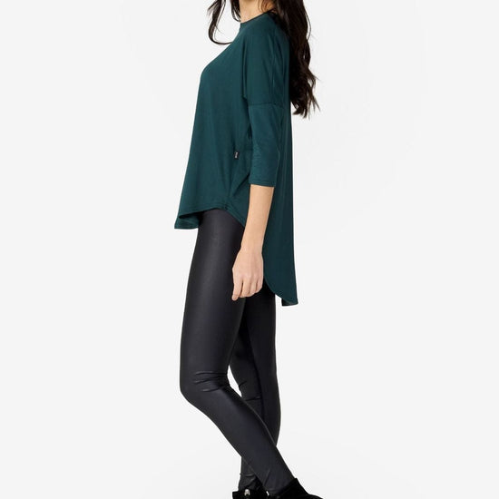 Side of a Woman wearing a green 3/4 length tee.